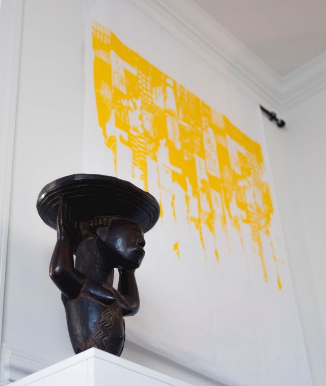 A Luba caryatid stool in front of El Anatsui, Untitled (detail), circa 1988. Photo: Emma Howells. Courtesy of Olusanya Ojikutu.